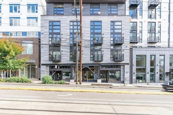 A multi-story building with a modern architectural design, featuring balconies and large windows. - Broadway-Condotel on First Hill (Seattle)