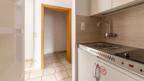 A compact kitchen with a built-in stove, sink, and wooden cabinets.