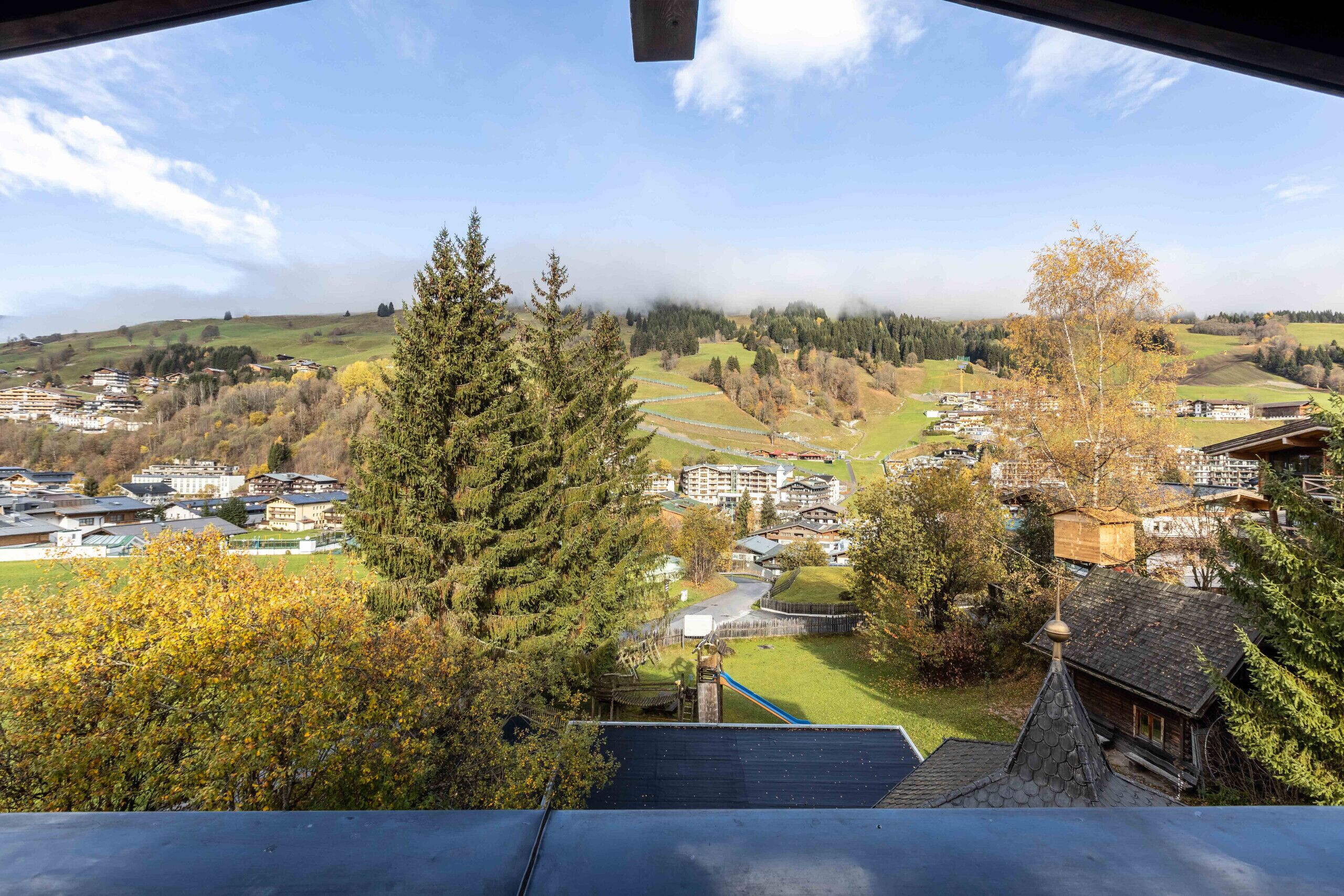 A panoramic view of a town with buildings, trees, and a river.