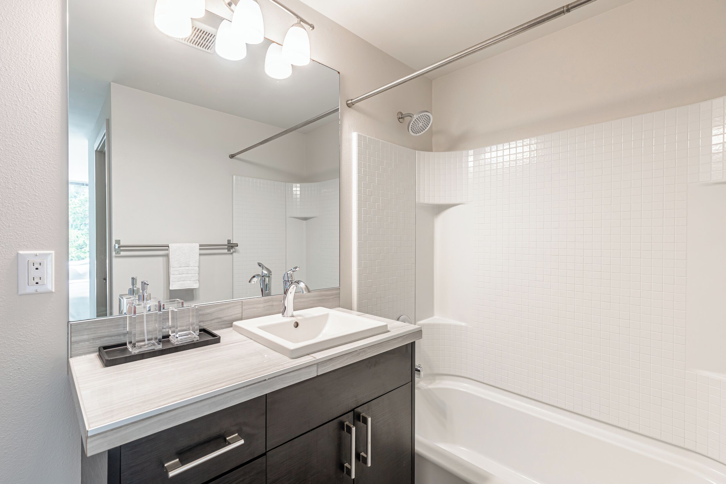 Ein modernes Badezimmer mit Waschbecken, Spiegel und Dusche.