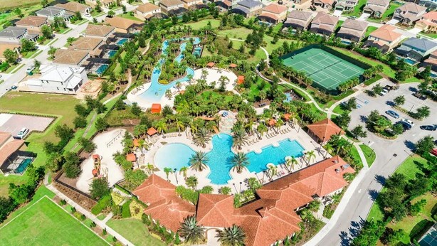 An aerial view of a residential area with a central swimming pool, tennis courts, and a landscaped park area. - Spacious 5-bedroom townhome with WiFi, AC in delightful Davenport (Davenport)
