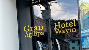 A hotel entrance with glass doors and a metal handle. The name 'Gran Agllipa Hotel Wayin' is visible on the glass. - GRAN HOTEL (Yungay)