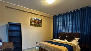 A bedroom with a bed, a desk, a chair, a bookshelf, and a painting on the wall. - GRAN HOTEL (Yungay)