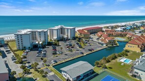 A coastal hotel with multiple buildings, a parking lot, and a marina.