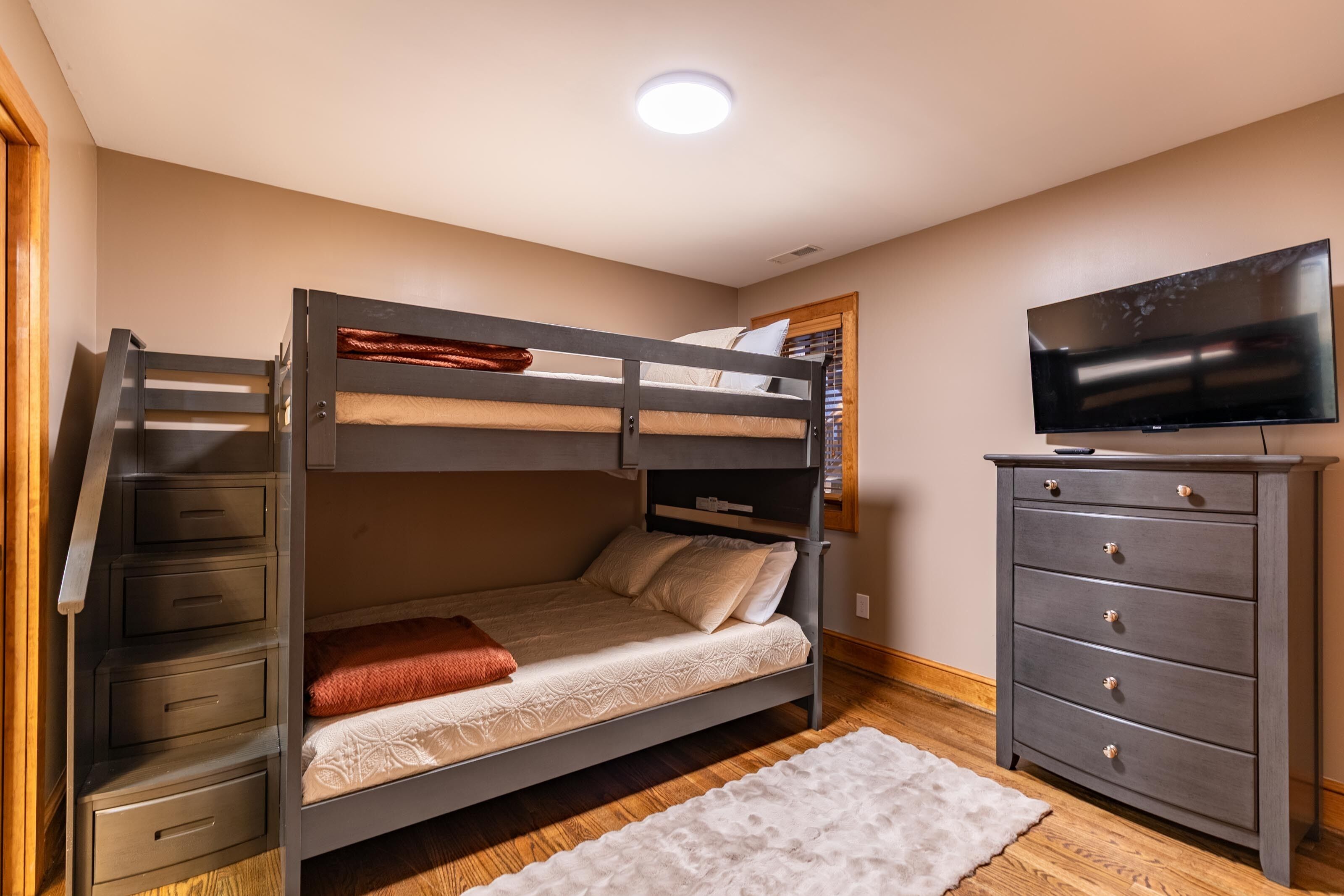 Habitación con literas, televisión y cómoda.