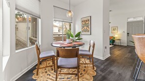 A dining area with a round table, four wooden chairs, a woven rug, and a hanging light fixture. -  Best Scottsdale location. Shopping, Food, Golf, near (Scottsdale)