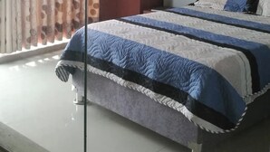 A bedroom with a bed, a wardrobe, and a curtain. - HOTEL TERRA (Ayacucho)