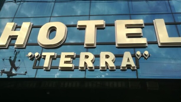 A modern hotel building with a reflective glass facade and the name "HOTEL TERRA" prominently displayed. - HOTEL TERRA (Ayacucho)