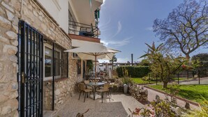 A stone building with a patio area featuring outdoor seating and umbrellas. - RentitSpain · Little Paradise on the Costa del Sol (Torremolinos)