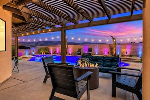 A poolside area with a fire pit, outdoor seating, and string lights. - Pool, Spa & Hot Tub! Golf Green 5BR near Coachella & Palm Springs-Jamaica Sands (Bermuda Dunes)