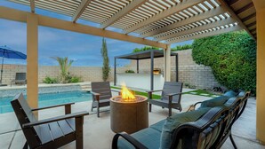 An outdoor patio with a fire pit, seating, and a pool. - Pool, Spa & Hot Tub! Golf Green 5BR near Coachella & Palm Springs-Jamaica Sands (Bermuda Dunes)