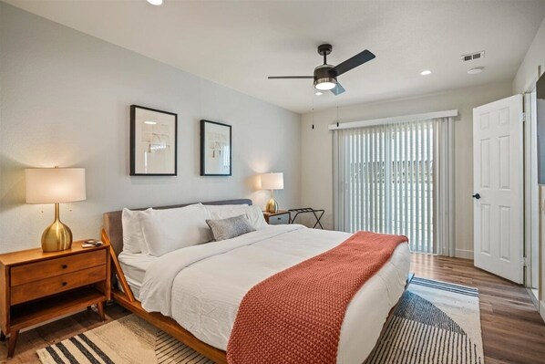 A bedroom with a bed, two bedside lamps, a ceiling fan, and a window with blinds. - Pool, Spa & Hot Tub! Golf Green 5BR near Coachella & Palm Springs-Jamaica Sands (Bermuda Dunes)