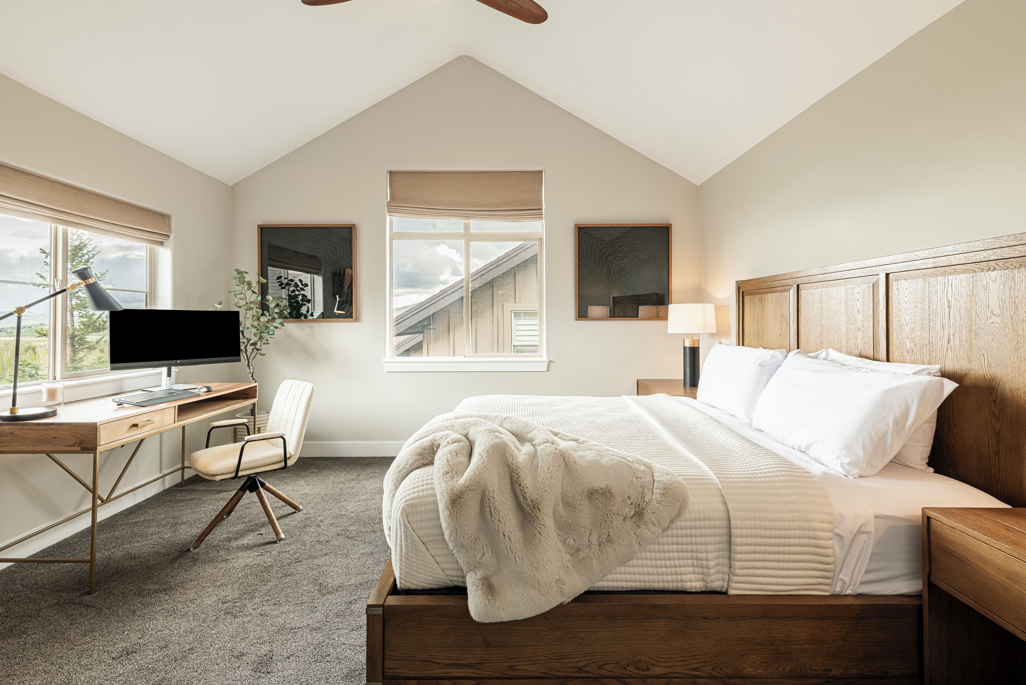 Een slaapkamer met een bed, bureau, stoel en een raam.