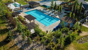 Ein Wohnhaus mit Schwimmbad, Liegestühlen und einer überdachten Terrasse.