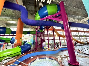 An indoor water park with multiple slides and a pool area.