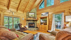A cozy log cabin interior with a fireplace, comfortable seating, and large windows. - Stunning Surroundings, Hot Tub Soaks, S'mores & Nearby Attractions - Our Favorite Place (Blue Ridge)