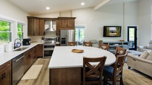 Une cuisine moderne avec des meubles en bois, des appareils en acier inoxydable et un grand îlot central.