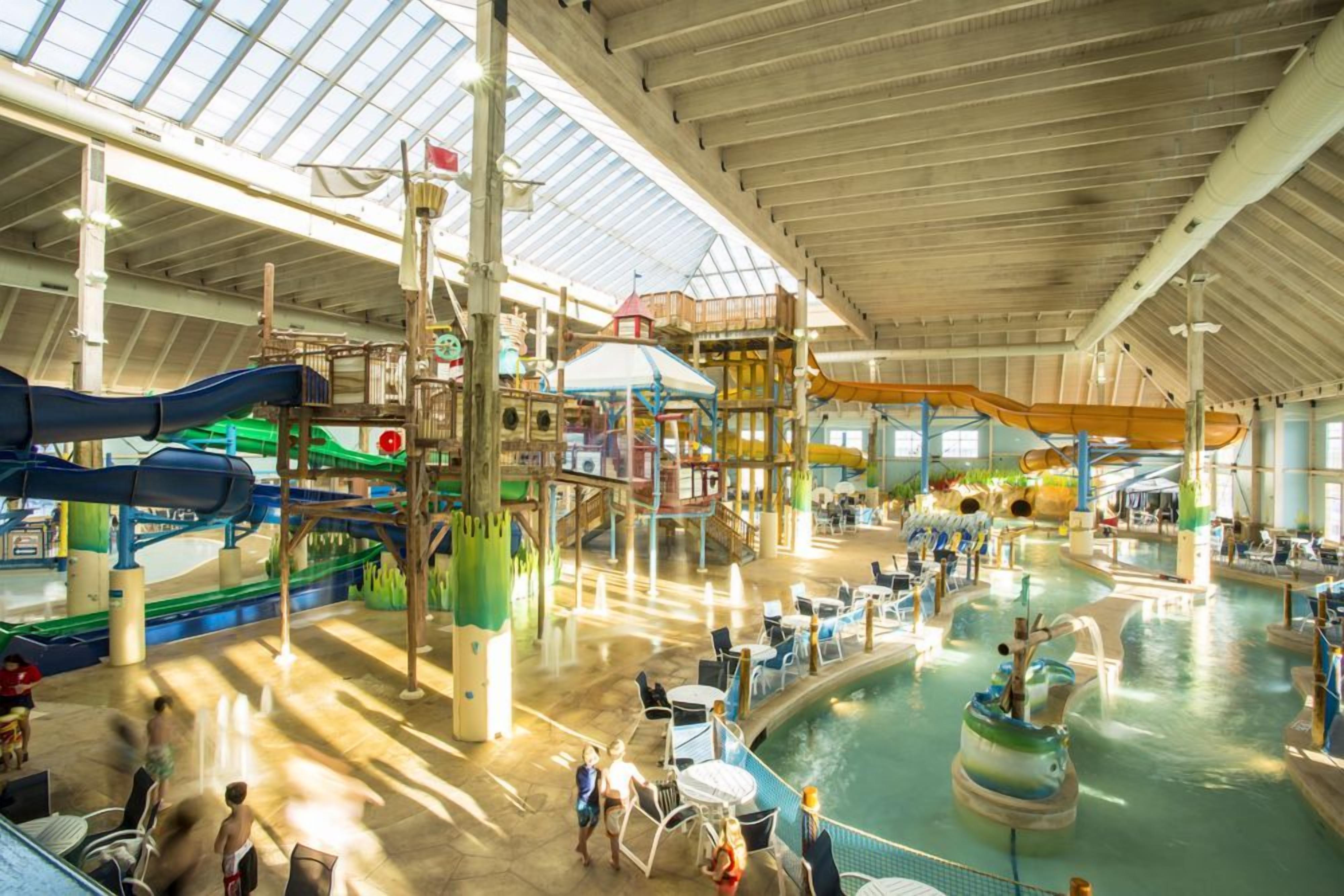 An indoor water park with slides, pools, and play structures.