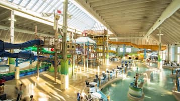An indoor water park with slides, pools, and play structures.
