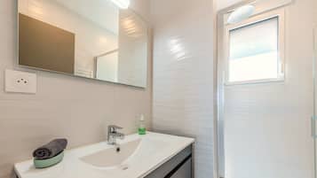 Regadera, secadora de cabello, toallas