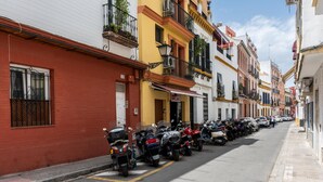 Une rangée de motos garées le long d’une rue étroite, bordée d’immeubles aux couleurs vives.