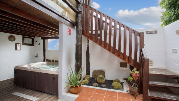 A spa area with a hot tub, wooden staircase, and potted plants. - Vacation Villa 'Casa Rural La Molina' with Mountain View, Private Terrace and Wi-Fi (Máguez)
