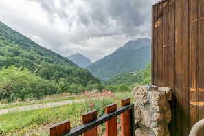 Eine gebirgige Landschaft mit einer Holzhütte und einer Steinmauer.