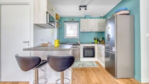 Una cocina moderna con comedor, ventana y refrigerador.