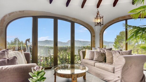 A spacious living area with a large glass coffee table, a beige sofa, and a potted plant. - Villa 'Caroix' with Sea View, Wi-Fi and Air Conditioning (Xàbia)