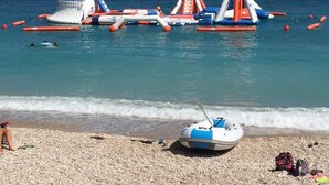 A beach with inflatable water toys and a small boat on the shore. - Villa 'Caroix' with Sea View, Wi-Fi and Air Conditioning (Xàbia)
