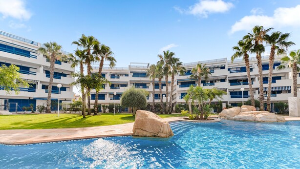 Un hôtel doté d’une piscine, de palmiers et d’un immeuble à plusieurs étages.