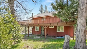 A two-story house with a wooden deck and a covered porch. - New! Arcade Games, Hot Tub,  Fire Pit, BBQ, 3:2 (Oakhurst)