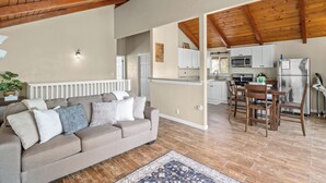 A cozy living room with a sofa, a patterned rug, and a wooden ceiling. - New! Arcade Games, Hot Tub,  Fire Pit, BBQ, 3:2 (Oakhurst)