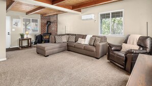 A spacious living room with a sectional sofa, a leather armchair, and a fireplace. - New! Arcade Games, Hot Tub,  Fire Pit, BBQ, 3:2 (Oakhurst)