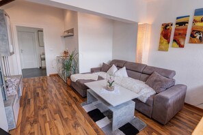 A modern living room with a sofa, coffee table, and a plant. - Apartment 'Kuchler' with Mountain View, Private Terrace and Wi-Fi (Riffian)