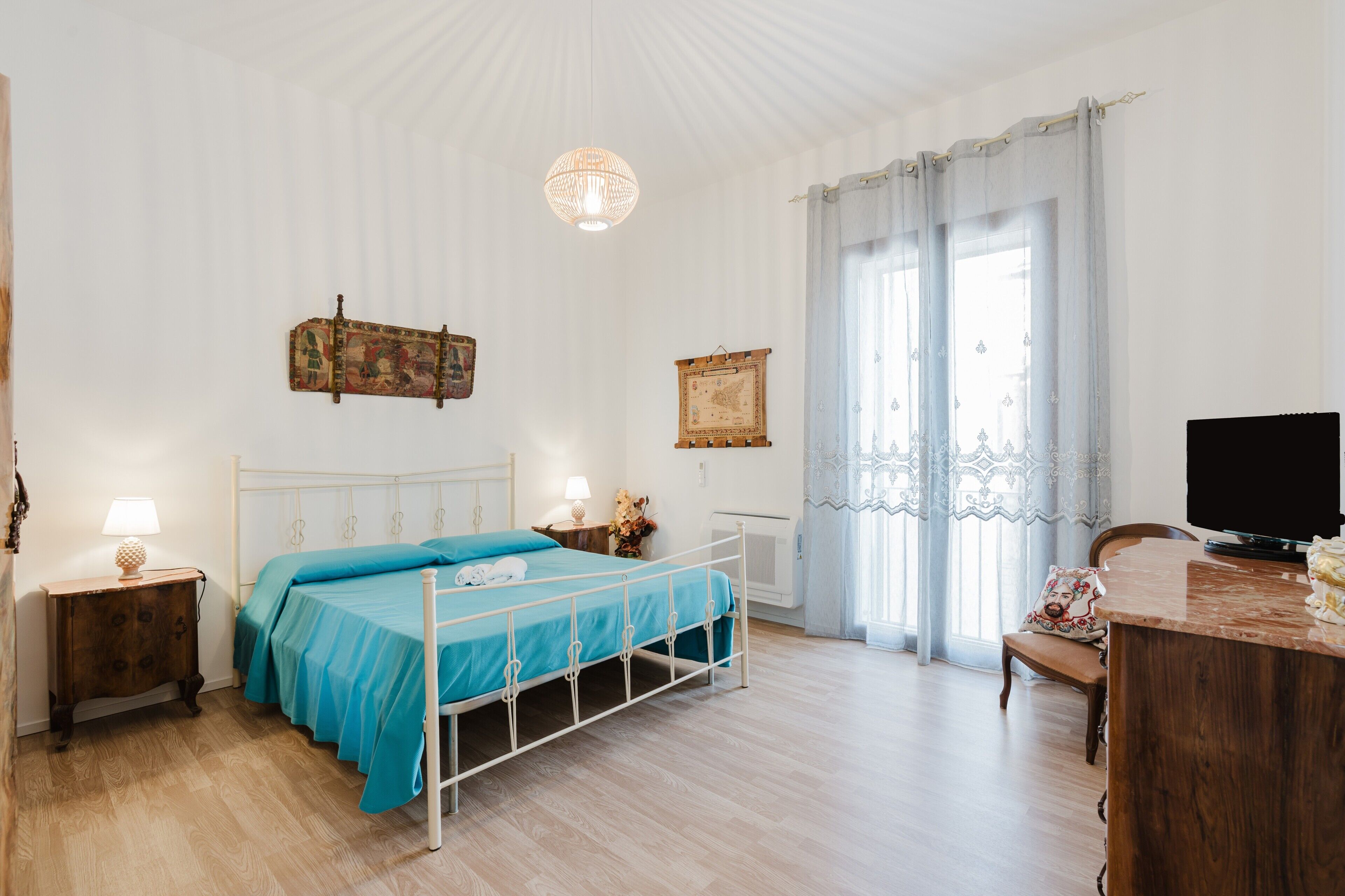 Une chambre à coucher comprenant un lit, une table de chevet, une lampe et un téléviseur.