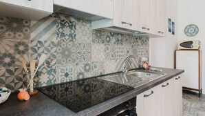 A kitchen with patterned tiles, a sink, and cabinets. - Holiday Home 'La Vanedda' with Private Terrace, Wi-Fi and Air Conditioning (Partanna)