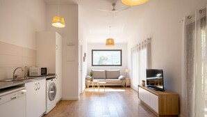 Una cocina moderna con microondas, lavadora y piso de madera.