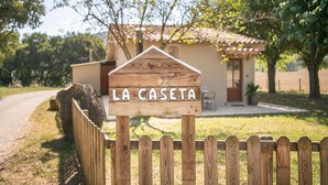 Un letrero de madera que dice 'LA CASETA', indicando el nombre de la propiedad.