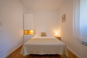 A bedroom with a bed, bedside lamps, a nightstand, a wardrobe, and a picture on the wall. - Mountain Country House with Private Jacuzzi (Montagut)