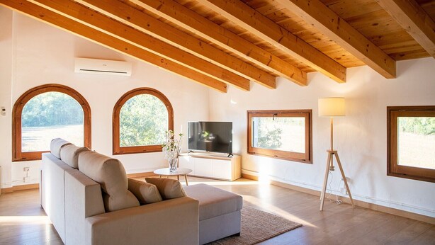 A living room with a sofa, TV, lamp, and arched windows. - Holiday Home 'L'Altell' with Mountain Views, Wi-Fi and Air Conditioning (Montagut)