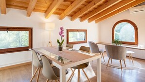 A dining area with a wooden ceiling, a glass table, and chairs. - Holiday Home 'L'Altell' with Mountain Views, Wi-Fi and Air Conditioning (Montagut)