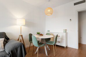 Una habitación moderna con una mesa de comedor, sillas, una lámpara y un armario.