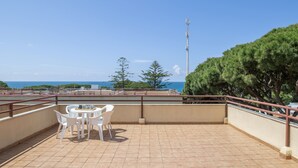 A rooftop terrace with a table and chairs, a railing, and a view of the sea and trees. - Apartment 'En Los Caños De Meca' with Sea View, Wi-Fi and Air Conditioning (Los Caños de Meca)