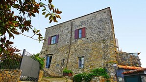 A stone building with two windows and a small entrance.
