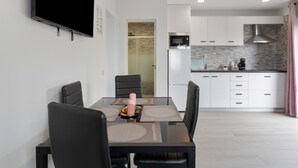 Una cocina moderna con armarios blancos, un microondas y una campana extractora de acero inoxidable.