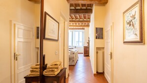 Un couloir avec une armoire en bois, des œuvres d’art encadrées et un radiateur.