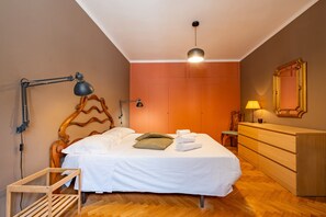 A bedroom with a wooden bed, a dresser, a desk, and a mirror. - Apartment 'Federico - In Pieno Centro' with Wi-Fi and Air Conditioning (Lucca)