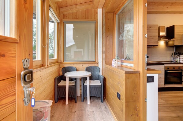 Un intérieur en bois comprenant un coin repas, une cuisine et une fenêtre donnant sur un paysage agréable.