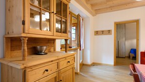 A wooden kitchen with cabinets, a bowl, and a table with chairs. - Apartment 'Piano Terra 3' with Mountain View, Private Terrace and Wi-Fi (Romeno)